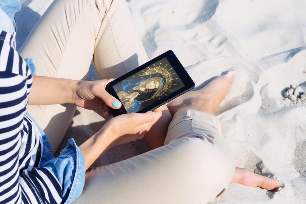 Woman holding tablet on the beach